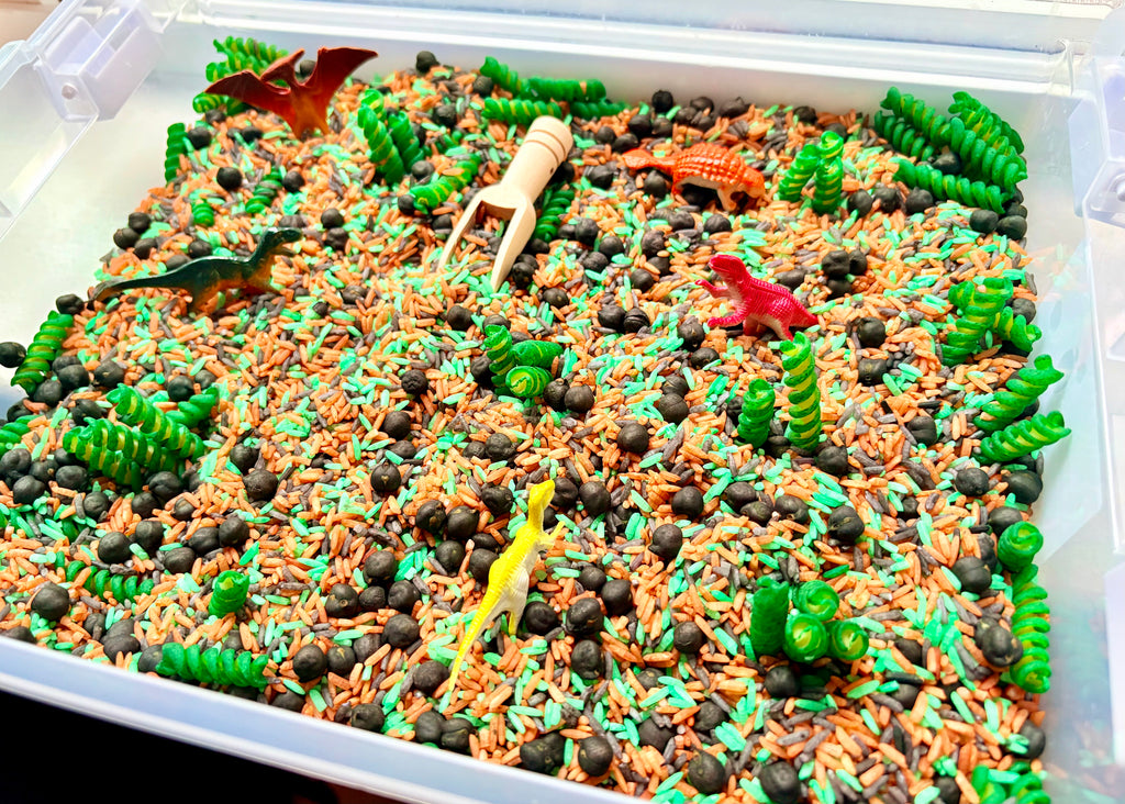 Close-up of colourful dinosaur-themed sensory filler and dinosaur play pieces
